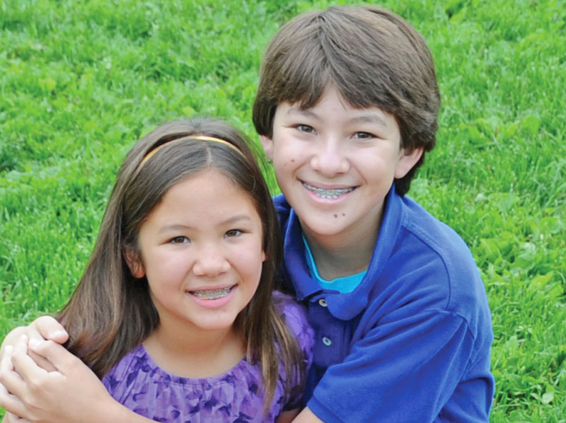 Boy and girl with smiling with braces.